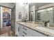 Bathroom featuring a double vanity, granite countertop, and a walk-in closet at 4021 S Teller St, Lakewood, CO 80235