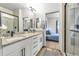 Bathroom with double sink vanity, granite countertops, and glass-enclosed shower, open to bedroom at 4021 S Teller St, Lakewood, CO 80235