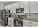 Modern kitchen featuring white cabinets, granite countertops, and stainless steel appliances at 4021 S Teller St, Lakewood, CO 80235