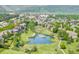 An aerial view featuring neighborhood buildings, mature trees, a walking path, and a pond at 7422 S Quail Cir # 1624, Littleton, CO 80127