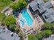 Overhead shot of sparkling pool featuring blue lounge chairs, mature trees, and a cozy pergola at 7422 S Quail Cir # 1624, Littleton, CO 80127