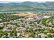 An aerial view featuring neighborhood buildings, mature trees, and distant mountains at 7422 S Quail Cir # 1624, Littleton, CO 80127