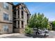 Three-story condo building with private balconies, reserved parking, and surrounding trees at 7422 S Quail Cir # 1624, Littleton, CO 80127