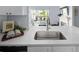 Bright kitchen features white quartz countertops, stainless steel sink, and views of the living area at 7422 S Quail Cir # 1624, Littleton, CO 80127