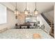 Open-concept dining area featuring modern lighting, granite counters, and staircase at 200 Primrose Path # 11, Breckenridge, CO 80424