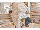 Modern fireplace featuring stacked stone with rustic wood and adjacent staircase at 200 Primrose Path # 11, Breckenridge, CO 80424