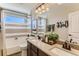 Bathroom features a double vanity, shower-tub combo with stylish tile, and bright natural light at 42704 Calusa Pines Rd, Elizabeth, CO 80107