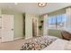 Cozy bedroom with floral comforter, green walls, light-colored carpet, and a large window at 42704 Calusa Pines Rd, Elizabeth, CO 80107