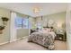 Well-lit bedroom featuring a floral comforter, desk area with a large window, and neutral carpet at 42704 Calusa Pines Rd, Elizabeth, CO 80107