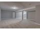 Large finished basement featuring neutral colored walls and carpet, with painted support beams across the ceiling at 5925 W 86Th Ave, Arvada, CO 80003