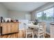 Bright dining area features hardwood floors, a round table, and large windows for plenty of natural light at 5925 W 86Th Ave, Arvada, CO 80003