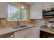 This view of the kitchen features stainless steel appliances, granite counters and a stainless steel sink at 5925 W 86Th Ave, Arvada, CO 80003