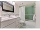 Bathroom with a vanity, decorative mirror, bathtub and shower with green tile at 5980 Dunraven Ct, Golden, CO 80403