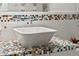 Close-up of a bathroom sink with colorful mosaic tile countertop and modern fixtures at 5980 Dunraven Ct, Golden, CO 80403