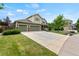 A cozy two-story home with a well-maintained lawn and an extended driveway for ample parking at 5980 Dunraven Ct, Golden, CO 80403