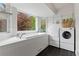 Bright laundry room with washer, dryer, sink and large window at 5980 Dunraven Ct, Golden, CO 80403