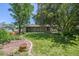 Backyard featuring green grass, lush trees, and a brick walkway surrounding a pot at 1073 Xenon St, Golden, CO 80401