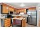 Well-equipped kitchen featuring wood cabinets, tile backsplash, stainless steel appliances, and an island at 1073 Xenon St, Golden, CO 80401