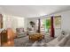 Staged living room featuring hardwood floors, white walls, large windows and stylish, neutral furniture at 1073 Xenon St, Golden, CO 80401