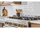 Modern kitchen features stainless steel range with white backsplash, quartz counters, and wood cabinets at 900 Eldorado Ln, Louisville, CO 80027
