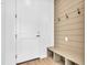 Welcoming mudroom with shiplap accent wall, coat hooks, and bench with storage at 900 Eldorado Ln, Louisville, CO 80027