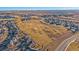 This aerial view shows a development with homes bordering a green space and roadways at 1392 S Duquesne Cir, Aurora, CO 80018