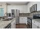 Modern kitchen with stainless appliances, granite counters, and tile backsplash at 1392 S Duquesne Cir, Aurora, CO 80018