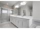 Modern bathroom featuring a walk-in shower, double vanity, and a large mirror at 23895 E Rocky Top Pl, Aurora, CO 80016