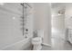 Bathroom featuring white tile surround, shower-tub combo, and toilet at 23895 E Rocky Top Pl, Aurora, CO 80016