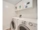 Functional laundry area featuring a washer, dryer, and upper cabinets for storage at 14130 E Temple Dr # T01, Aurora, CO 80015