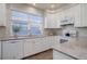 Modern kitchen with white cabinets and granite countertops at 9877 Grove St # C, Westminster, CO 80031