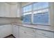 Updated kitchen with white cabinets, granite counters, and a large window at 9877 Grove St # C, Westminster, CO 80031