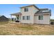 Backyard view showcasing the patio with grill, house's rear facade, and partial roof with solar panels at 23814 E 36Th Pl, Aurora, CO 80019