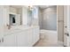 Bright bathroom showcasing a double vanity, modern fixtures, and decorative tiled shower at 23814 E 36Th Pl, Aurora, CO 80019