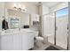 Bright bathroom featuring a glass enclosed shower with a built-in bench and white vanity with quartz countertops at 23814 E 36Th Pl, Aurora, CO 80019