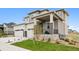 Modern two-story home with a two-car garage, stone accents, covered porch, and green front yard landscaping at 23814 E 36Th Pl, Aurora, CO 80019