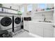 Well-lit laundry room featuring sleek, modern appliances, white cabinetry and shelving for ample storage at 23814 E 36Th Pl, Aurora, CO 80019