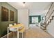 Cozy dining area with a modern table set, leading into a living room with abundant natural light and stairs at 14485 E Hawaii Cir # B, Aurora, CO 80012