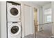 Upstairs hallway featuring a stacked washer and dryer, next to a closet and views to other rooms at 14485 E Hawaii Cir # B, Aurora, CO 80012