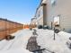 Fenced backyard showcasing a brick pathway partially covered in snow, perfect for outdoor enjoyment at 28314 E 6Th Pl, Watkins, CO 80137