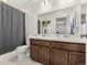 Bathroom with double sinks, spacious mirror, dark wood cabinets, and a shower with a gray curtain at 28314 E 6Th Pl, Watkins, CO 80137