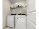 Functional laundry room featuring a white washer and dryer with a shelf for storage at 28314 E 6Th Pl, Watkins, CO 80137