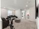 Open bonus room featuring an exercise bike, a large ottoman, and dark-colored seating at 28314 E 6Th Pl, Watkins, CO 80137