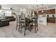 Open-concept living space with a dining area, kitchen, and living room featuring a leather couch and plenty of natural light at 28314 E 6Th Pl, Watkins, CO 80137