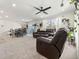 Bright and airy living room with plush carpets, a ceiling fan, and comfortable leather furniture at 28314 E 6Th Pl, Watkins, CO 80137
