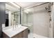 Elegant bathroom featuring a walk-in shower with glass doors, a modern vanity, and ample lighting at 1495 Vrain St # 110, Denver, CO 80204