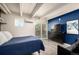 Relaxing bedroom with a dark blue accent wall, a bed, a dresser with TV, and a sliding glass door at 1495 Vrain St # 110, Denver, CO 80204