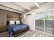 Comfortable bedroom with a cozy bed, built-in storage, and a sliding door leading to a balcony with city views at 1495 Vrain St # 110, Denver, CO 80204