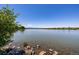 Picturesque view of a serene lake with a rocky shoreline and distant mountains at 1495 Vrain St # 110, Denver, CO 80204