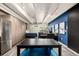 Modern living area with stainless steel refrigerator, bed, work space, and hardwood-style floors at 1495 Vrain St # 110, Denver, CO 80204